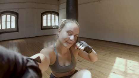 POV-of-cheerful-female-boxer-taking-selfie-after-workout-in-gym